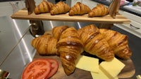 a tray with croissants, tomatoes and cheese on it